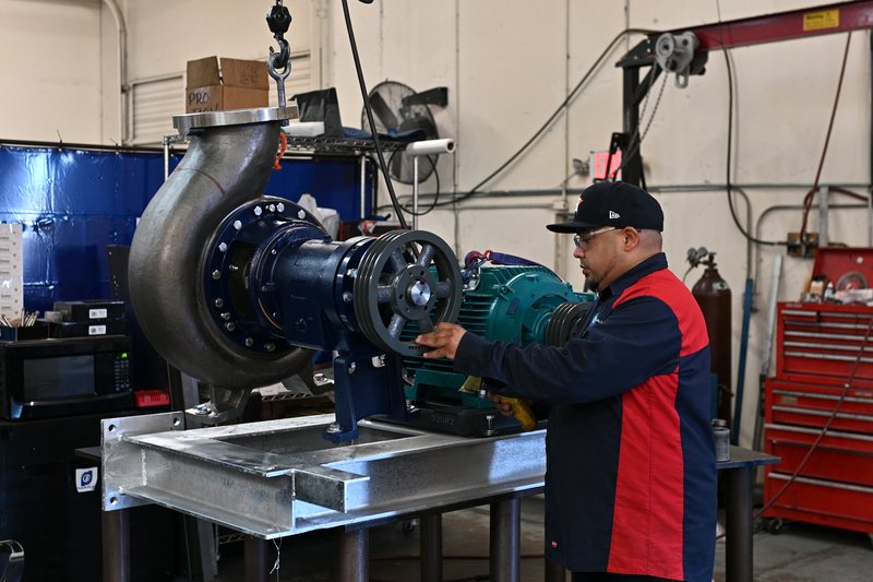 A Pinnacle-Flo technician building a pump unit on the bench