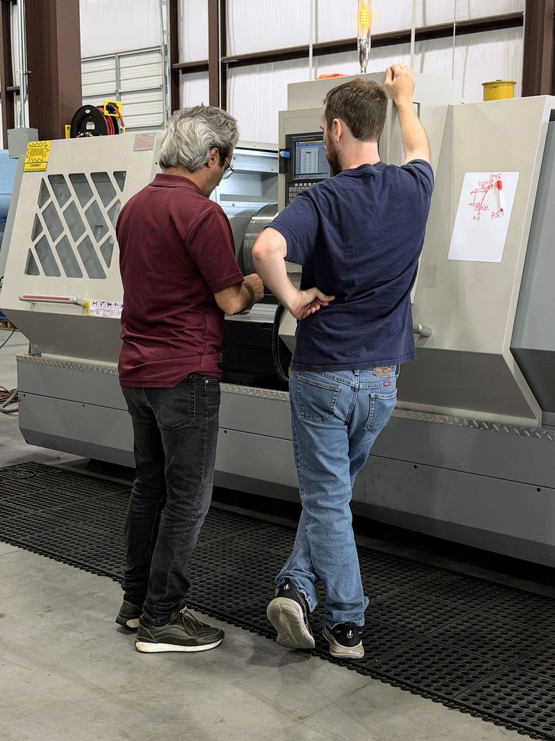 Pinnacle-Flo machinists setting up a CNC lathe